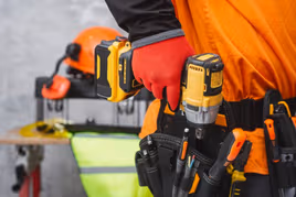 Person putting power tool in their tool belt