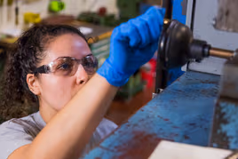 An engineer operating a metal injection molding machine