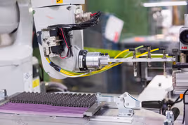 Robotic machine moving parts into trays