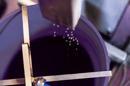 Feedstock dropping into a purple bin