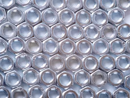 Die cast metal nuts laying in a pattern