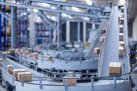 Conveyor belt moving boxes in a manufacturing facility